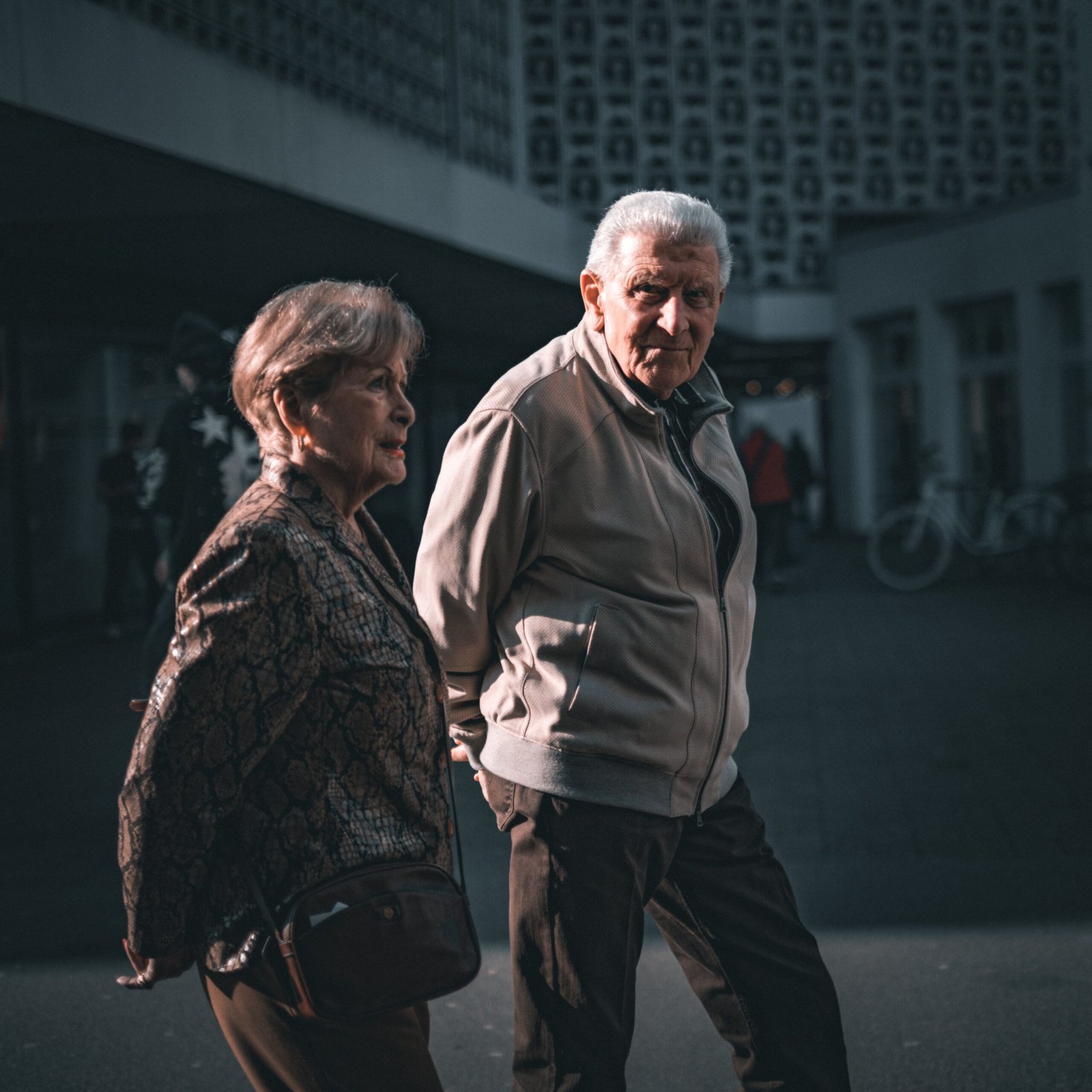 Elderly couple strolling in Trier, Germany during daytime.